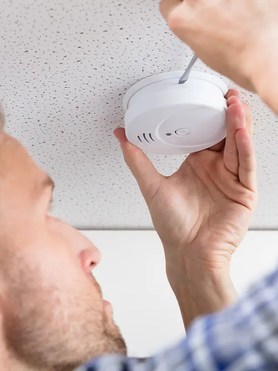 man installing smoke detector