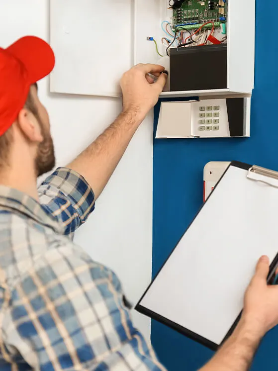 technician installingalarmpanel in home